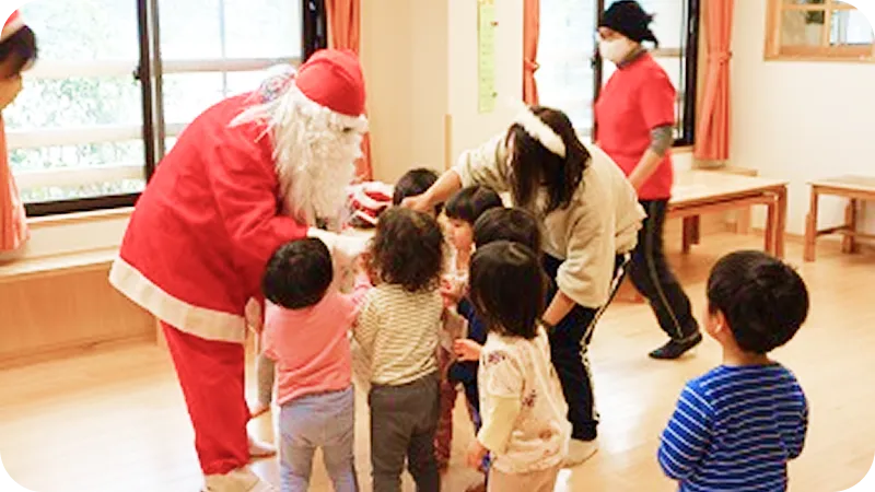 サンタクロースと触れ合いながら、クリスマス会を楽しむ子どもたちの様子