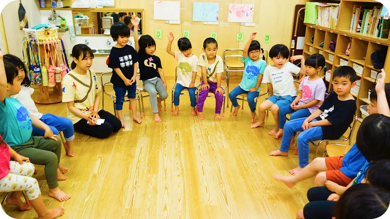 保育士がシャボン玉を飛ばし、子どもたちが楽しんでいる様子