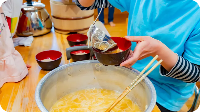 大鍋の汁物をよそっている様子