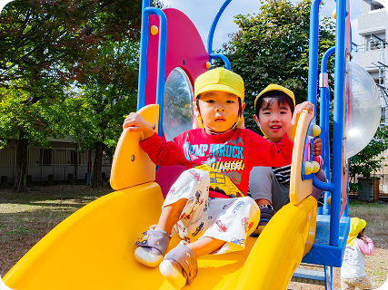 園児が滑り台を滑る様子